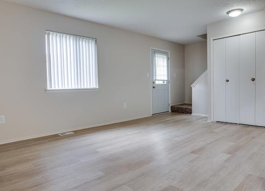 A room with a wooden floor and a white door.