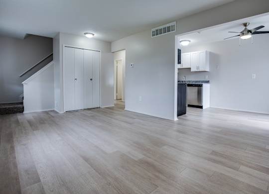 A spacious room with wooden flooring and a ceiling fan.