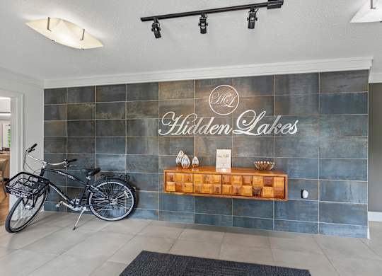 A bicycle is parked in front of a wall with a sign that reads
