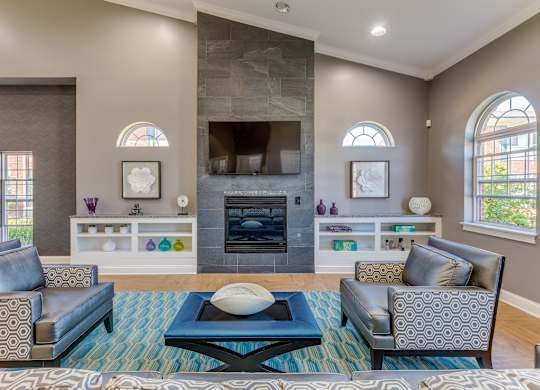 A clubhouse with a fireplace and a blue rug.