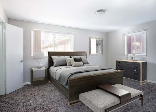 A bedroom with a large bed and a bench.