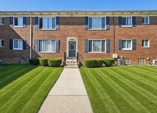 A brick building with a green lawn in front.