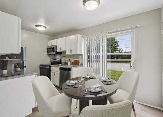 Modern kitchen with a dining table set for four at Versailles, 25026 E Rue Versailles, Oak Park, MI 