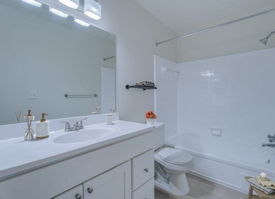 A white bathroom with a sink, toilet, and bathtub.