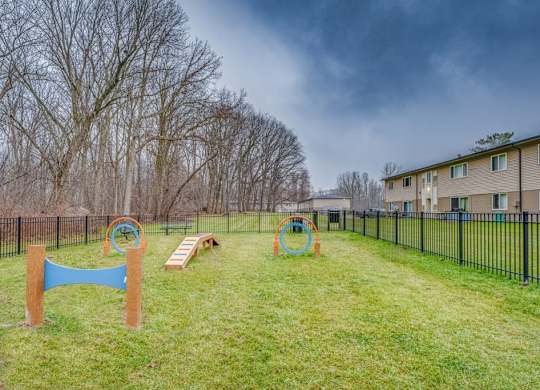 A playground with a blue swing set and a green slide.