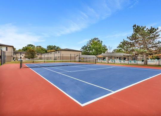 A tennis court with a blue and red surface and white lines.