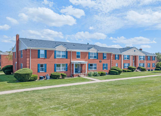 A red brick building with a green lawn in front.