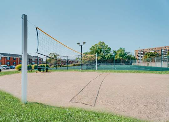 A tennis court with a net and a pole in the foreground.