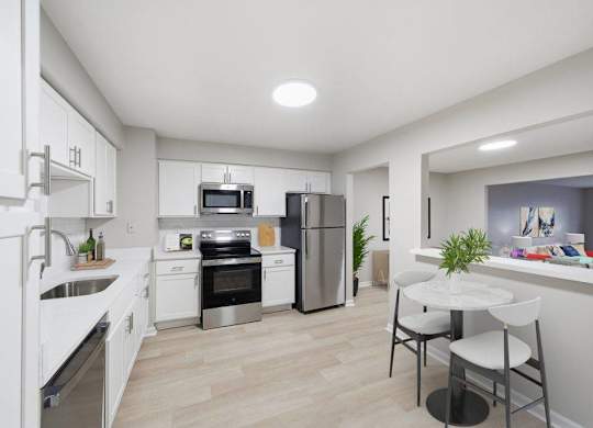 A modern kitchen with white cabinets and stainless steel appliances.