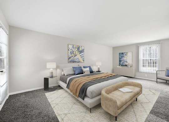 A bedroom with a large bed and a bench.