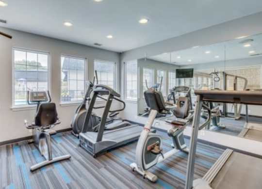 A gym with a treadmill, exercise bike, and other equipment.