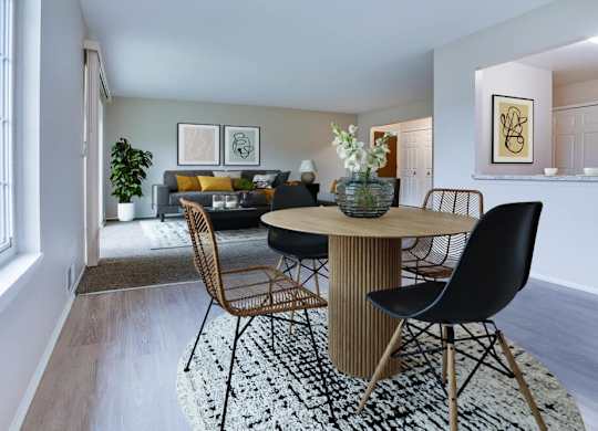 A dining room with a round table surrounded by chairs.