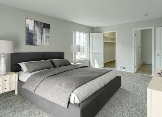 A bedroom with a large bed and a nightstand with a lamp.