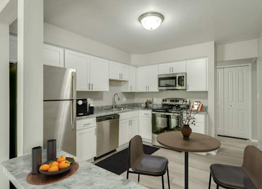 A kitchen with a table and chairs in the middle of it.