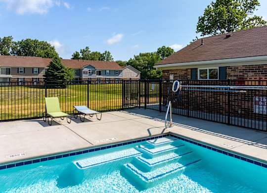 A pool with a slide and a fence.
