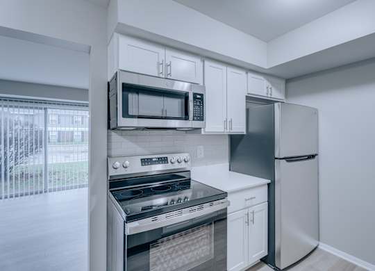 A kitchen with white cabinets and appliances.