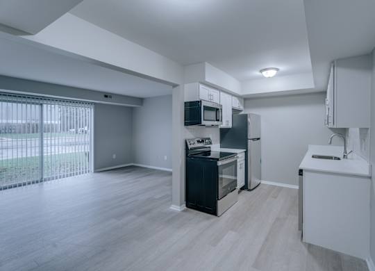 A kitchen with a black fridge and white cabinets.