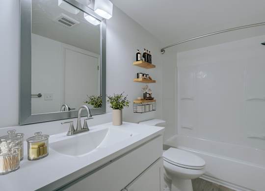 A white bathroom with a sink, toilet, and bathtub.