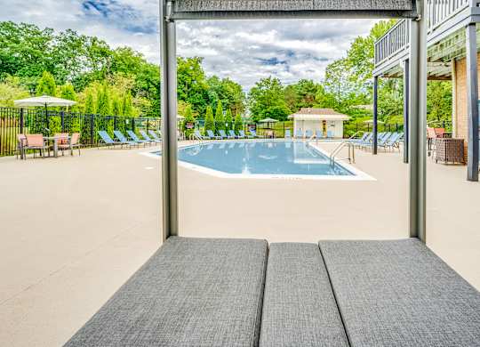 A large outdoor swimming pool with a view of the trees.