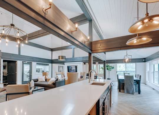 A modern kitchen with a large island and pendant lights.
