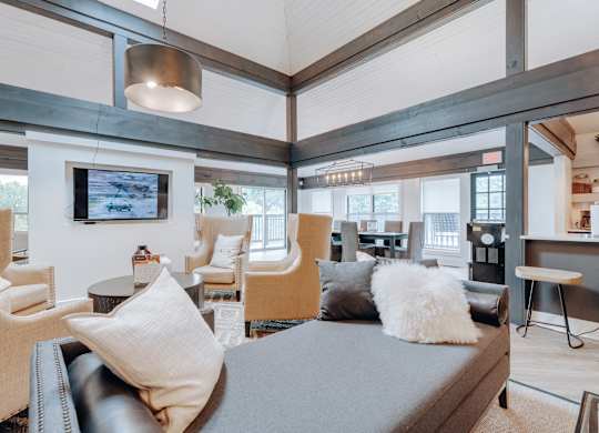 A modern living room with a grey sofa and a television mounted on the wall.