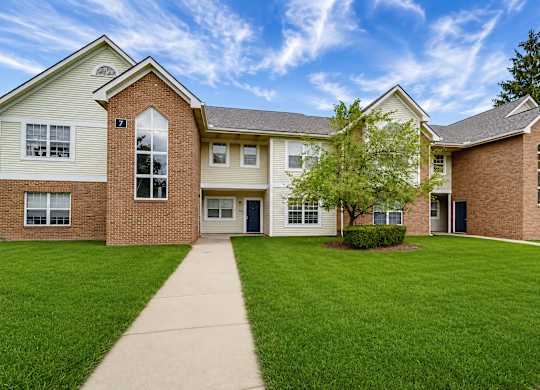 A building with a green lawn in front.