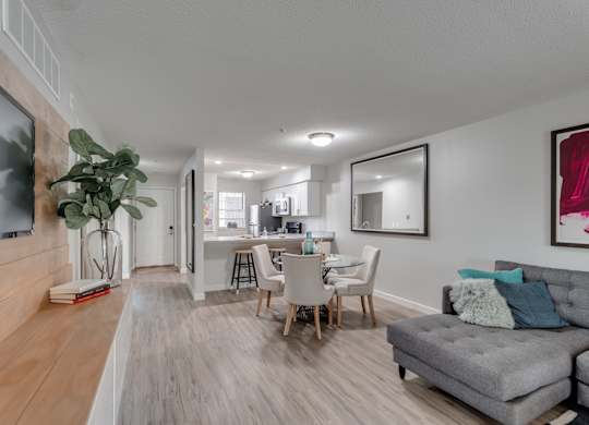 A living room with a grey couch and a wooden floor.