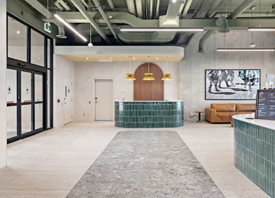 A reception area with a wooden door and a green tile counter.