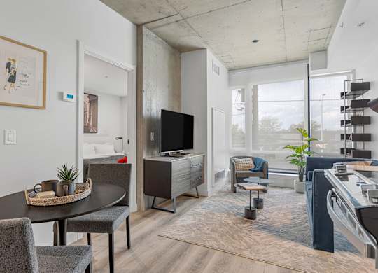 A modern living room with a flat screen TV and a dining table.