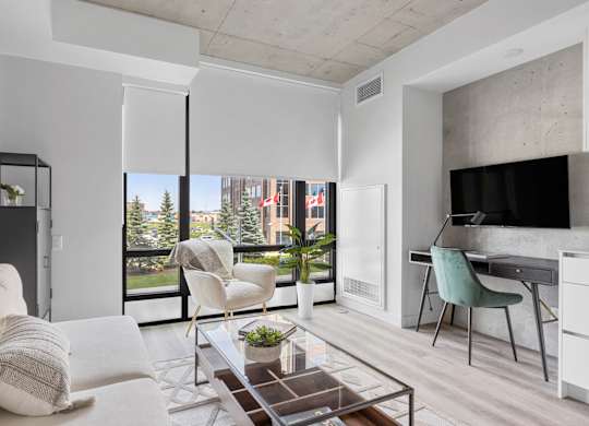 A modern living room with a white couch and a glass coffee table.