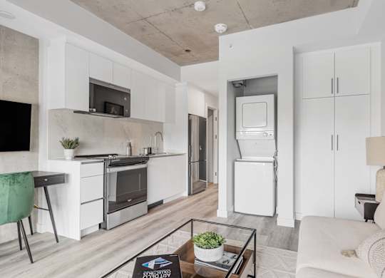 A modern kitchen with a refrigerator, oven, and microwave.