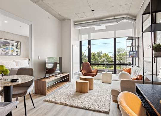 A modern living room with a dining table and chairs.