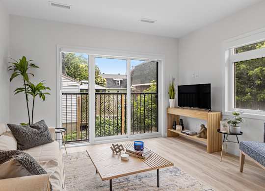 A living room with a couch, a coffee table, and a television.