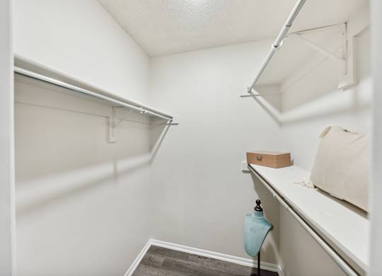 A small, white closet with a shelf and a hanging rod.