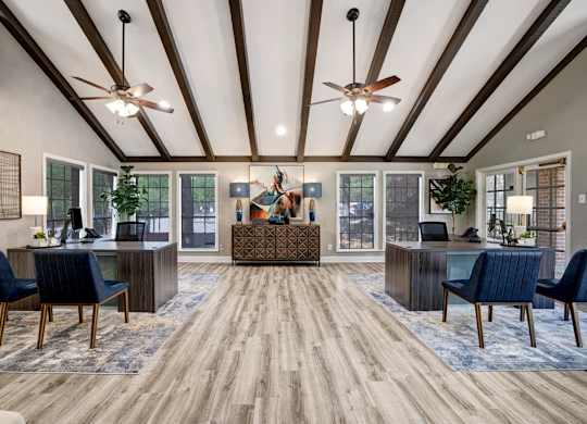 A spacious office with wood floors and ceiling fans.