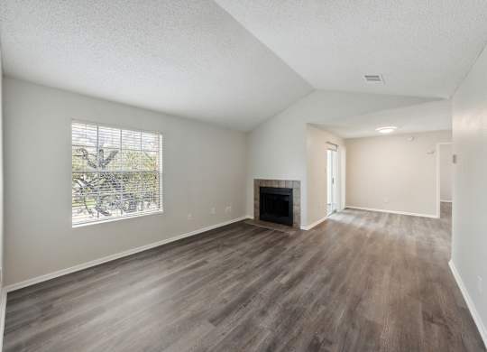 A room with a fireplace and wood flooring.