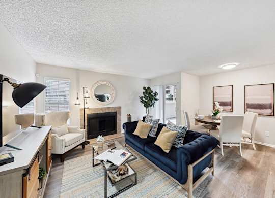 A living room with a blue couch and a fireplace.