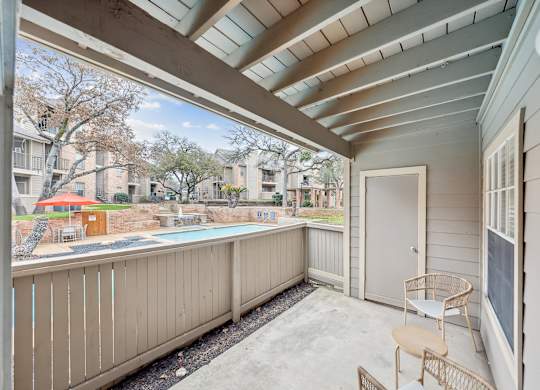 A balcony with a chair and a table is shown.