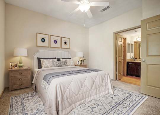 A bedroom with a large bed and a ceiling fan.