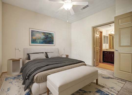 A bedroom with a large bed and a painting on the wall.