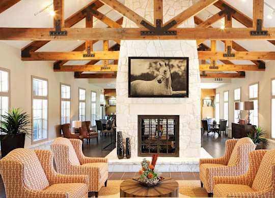 A living room with a fireplace and a painting of a dog.