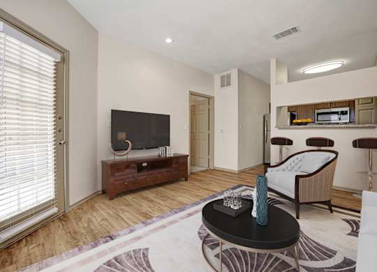 A living room with a black coffee table and a flat screen TV.
