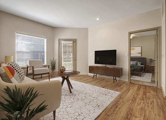 A living room with a sofa, a coffee table, a TV, and a plant.