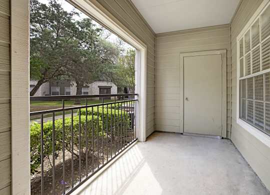 A balcony with a black railing and a white door.