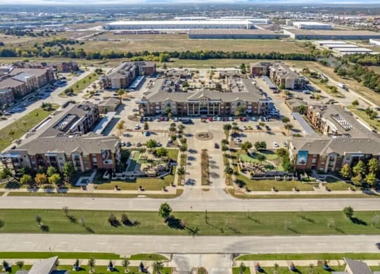 A large, modern building complex with a parking lot in front.