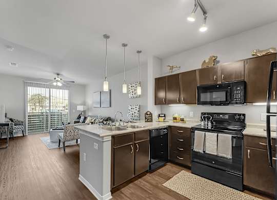 A kitchen with a black stove top oven and a white counter top.