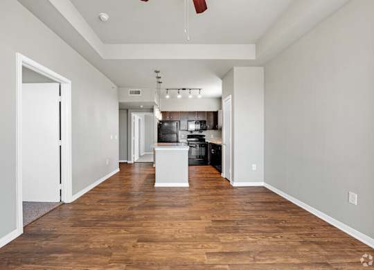A spacious room with wooden floors and white walls.