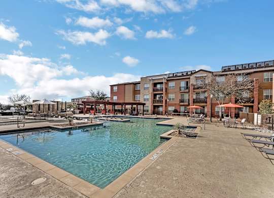 A large swimming pool in front of apartment buildings.