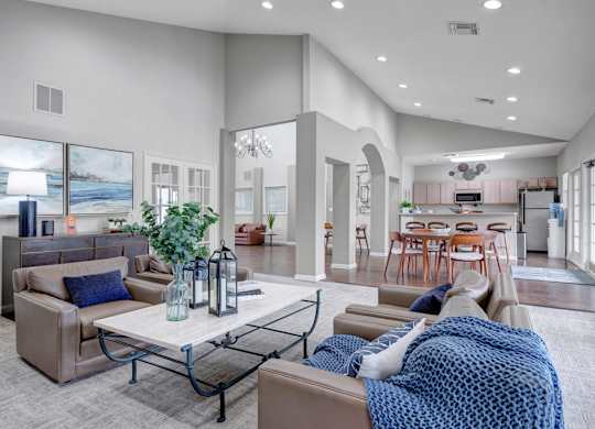 A modern living room with a couch, coffee table, and a view of the beach.