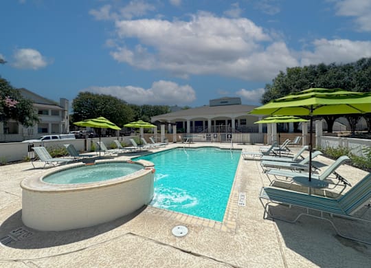 A pool area with sun loungers and umbrellas.